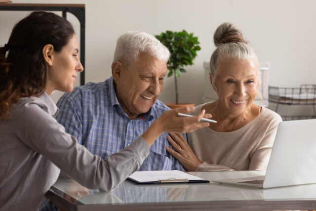 Female banking consultant meeting with elderly couple.