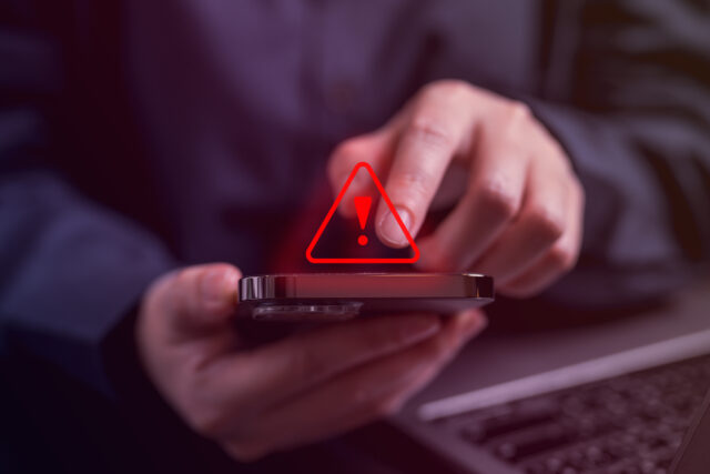 Person receiving a red warning notification when using smart phone.