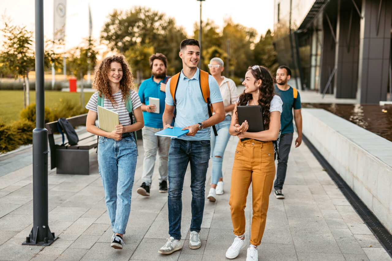 Group of college students walking on university's campus.