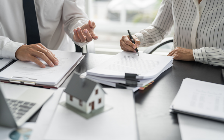 Financial counselor helps client with paperwork for owning a house. 